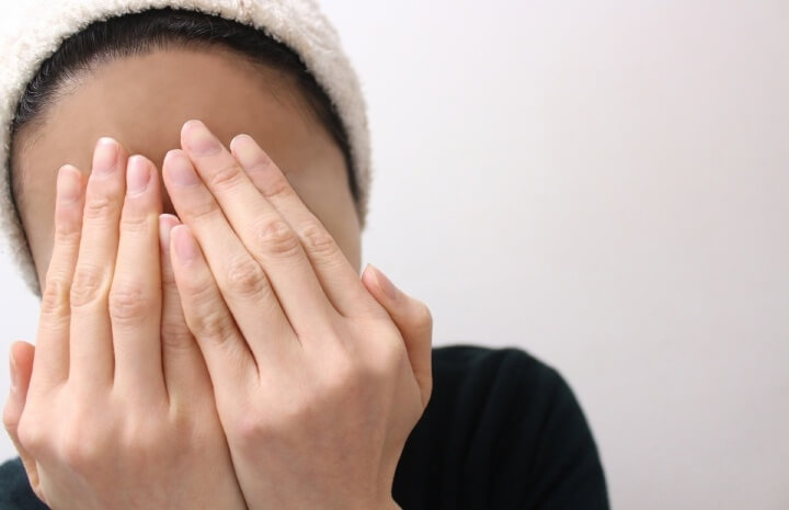 手で顔をかくす